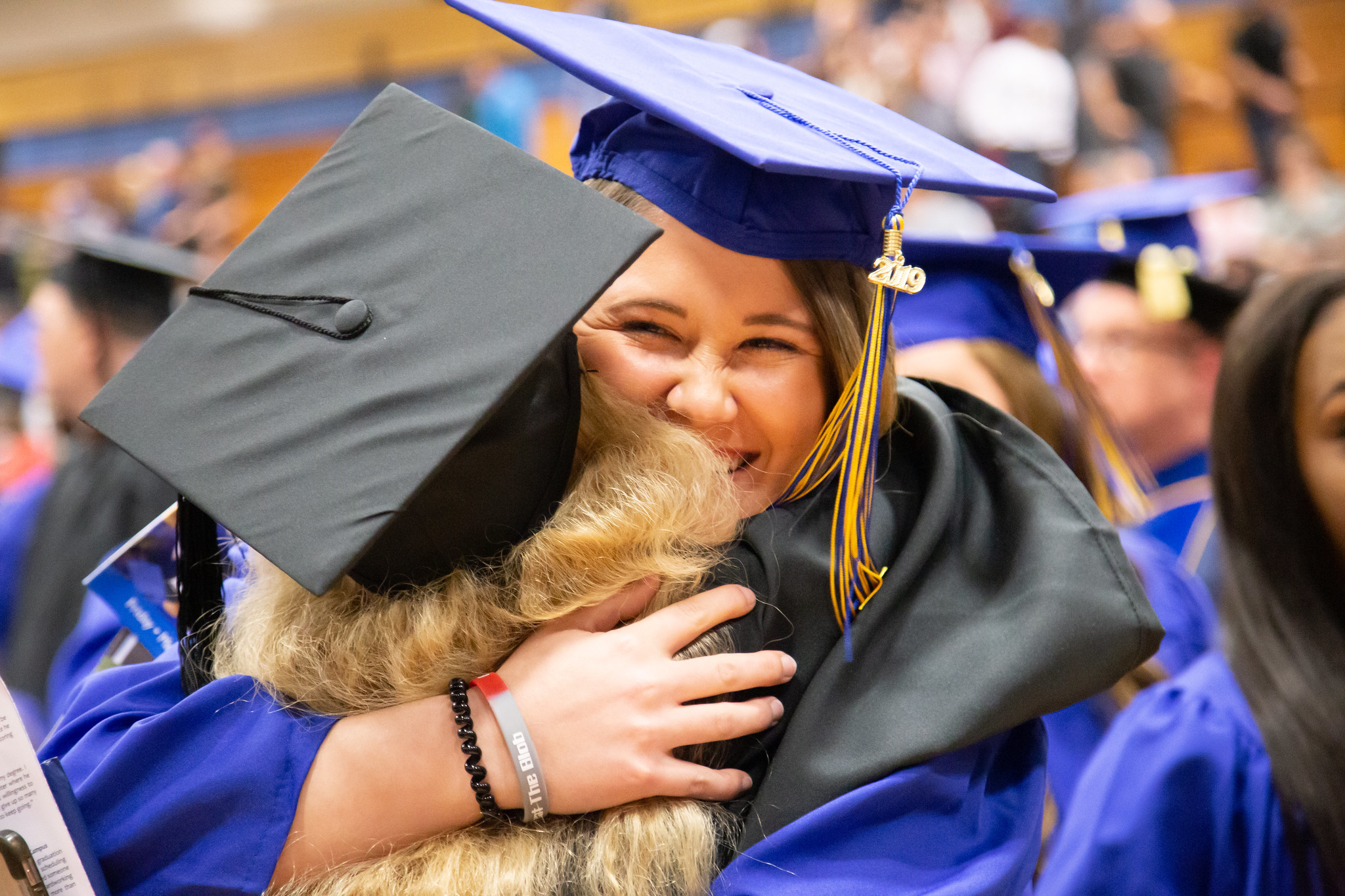 graduate and teacher embrace