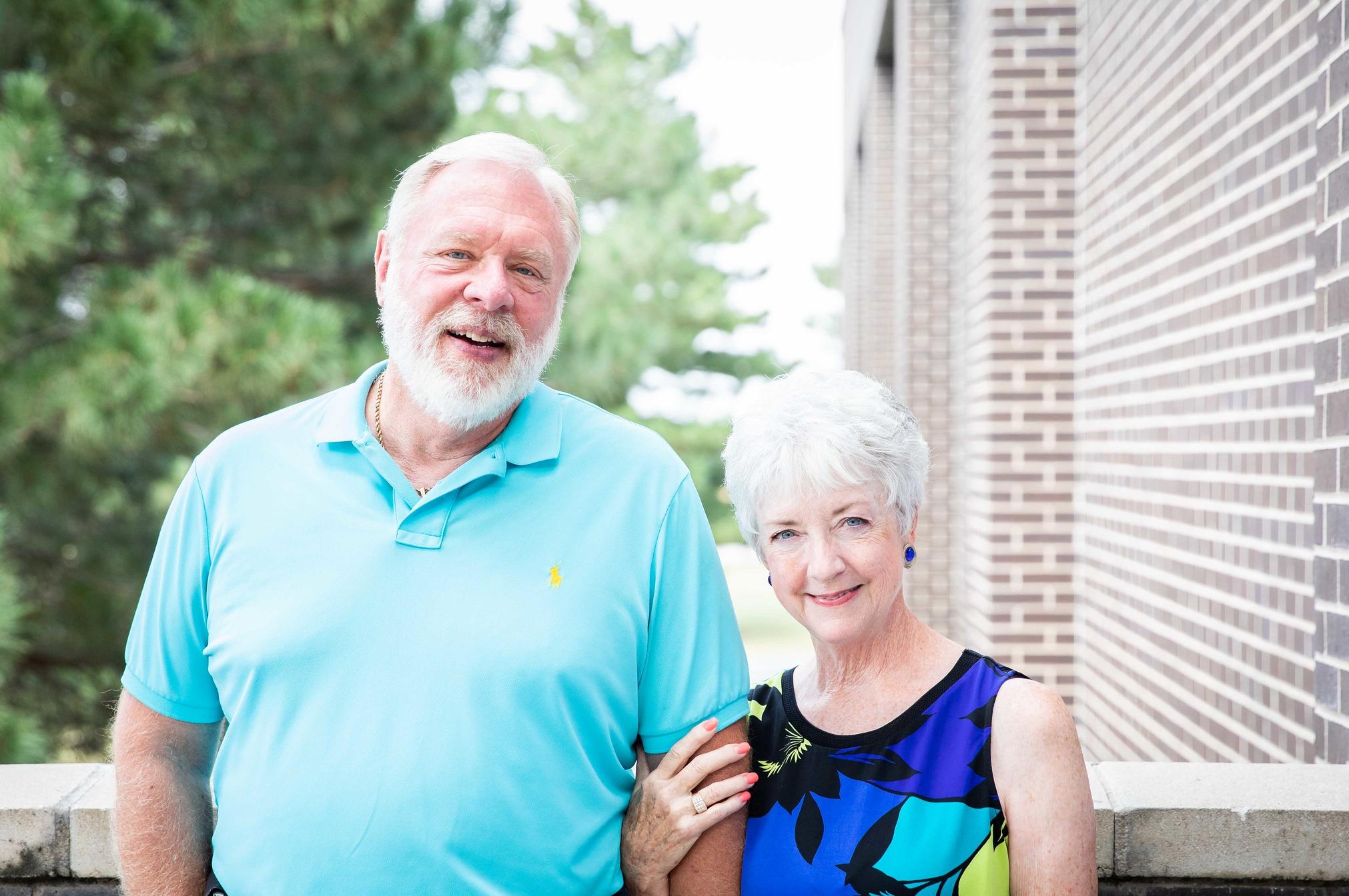 portrait of brad and sarah shirer in front of college