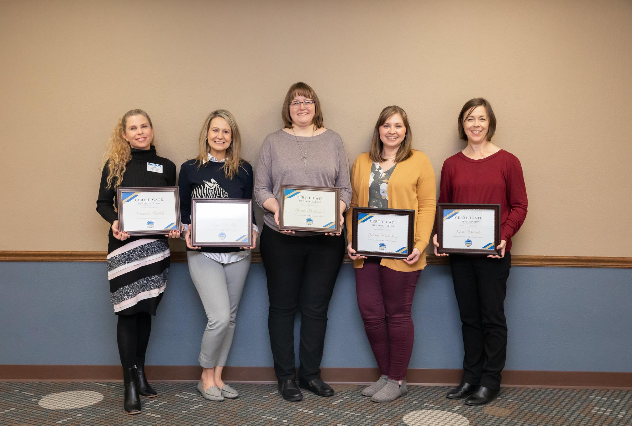 people standing with certificates