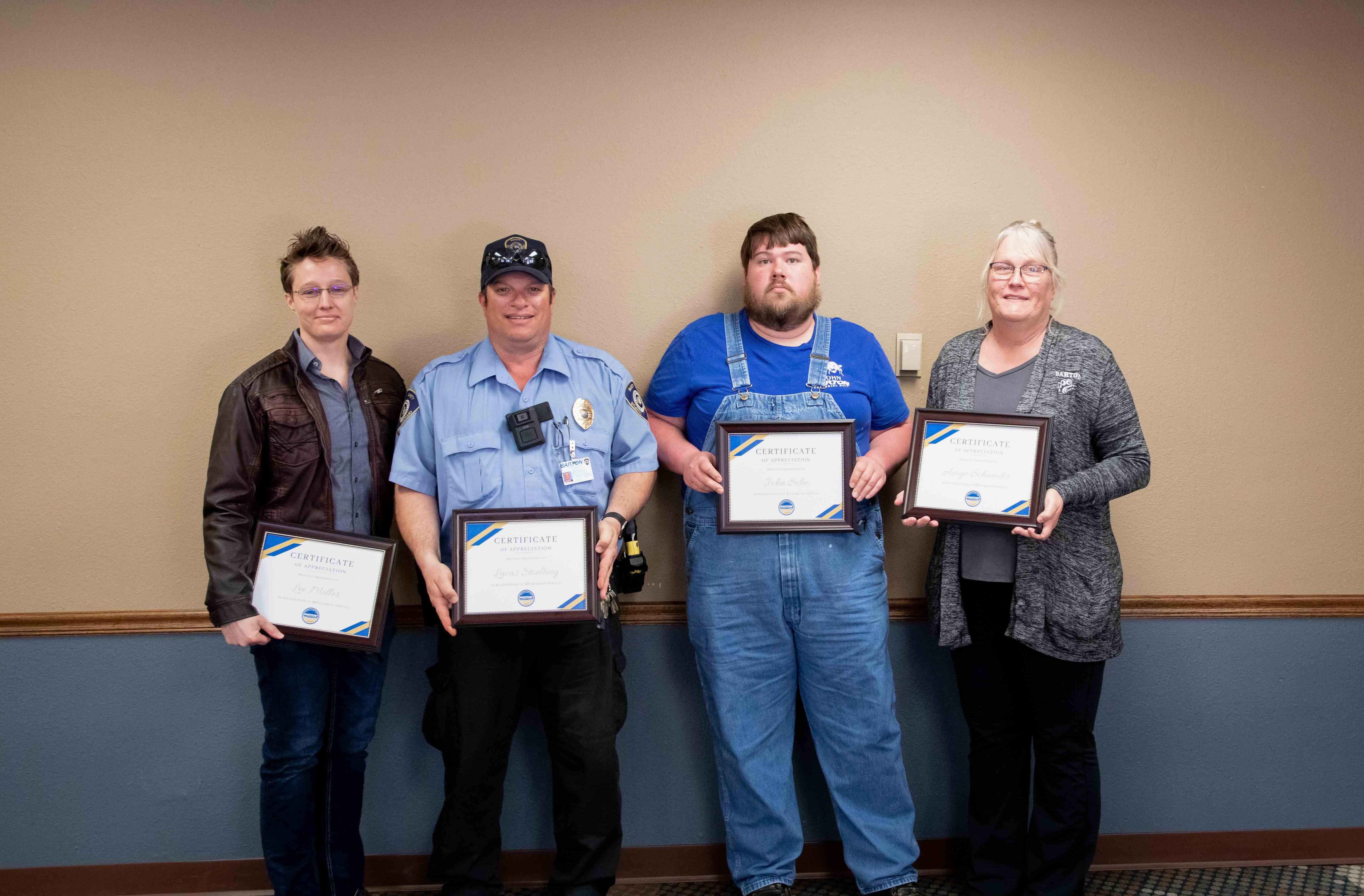 people standing with framed certificates 